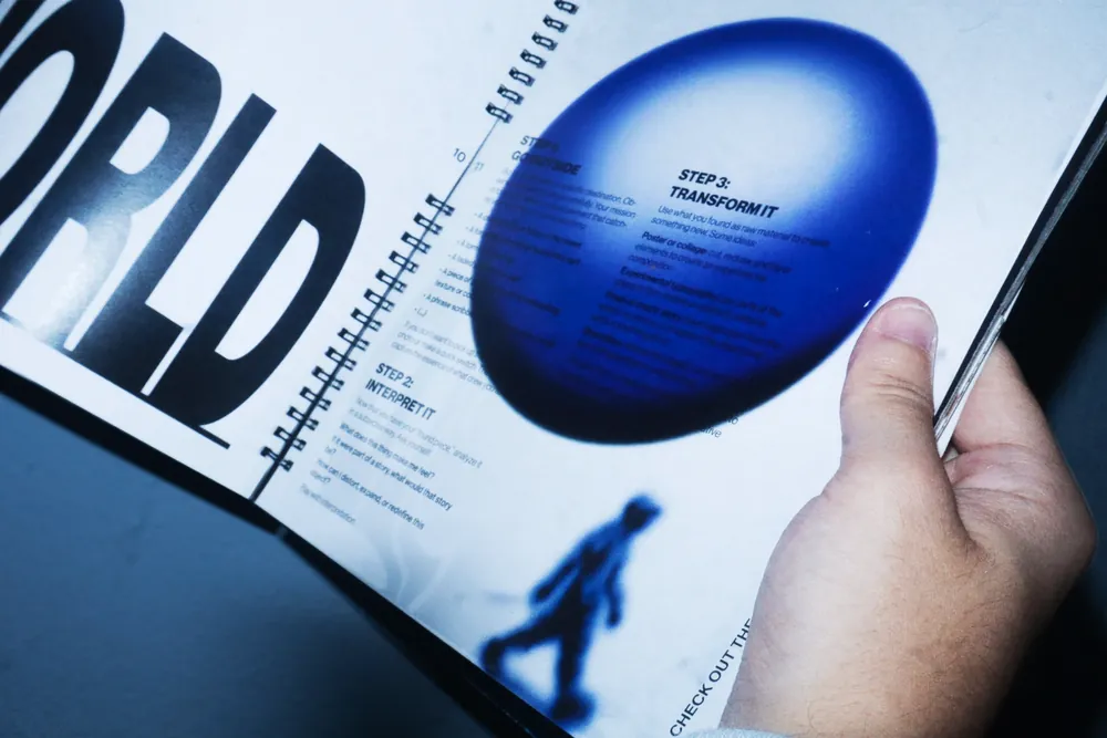 A spread with large display type and a blue 3D form, photographed at an angle