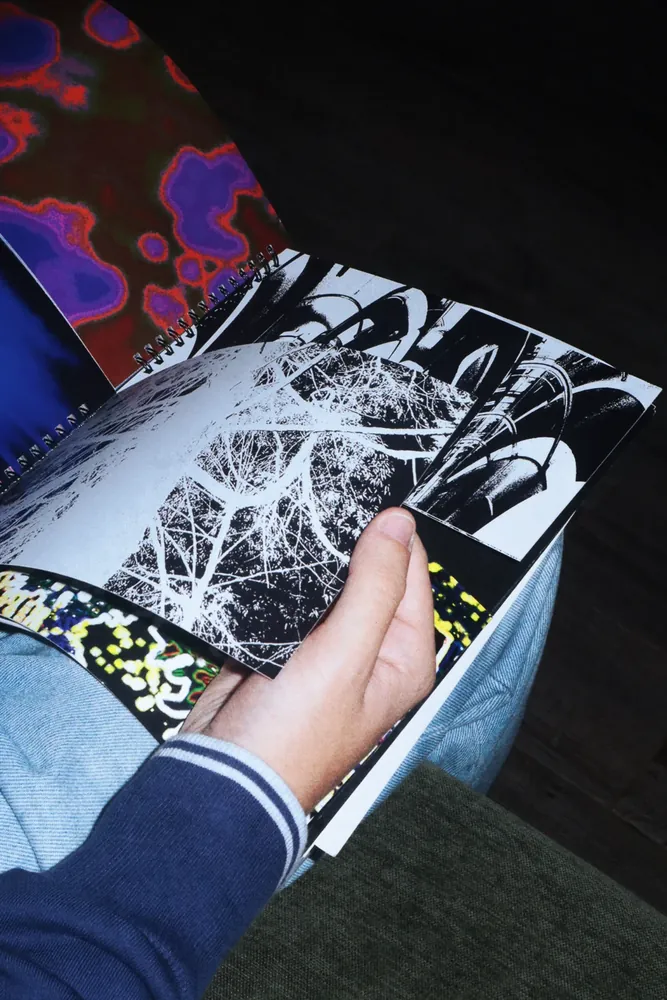 A DEBRIS spread held open, showing a dense black-and-white photographic composition