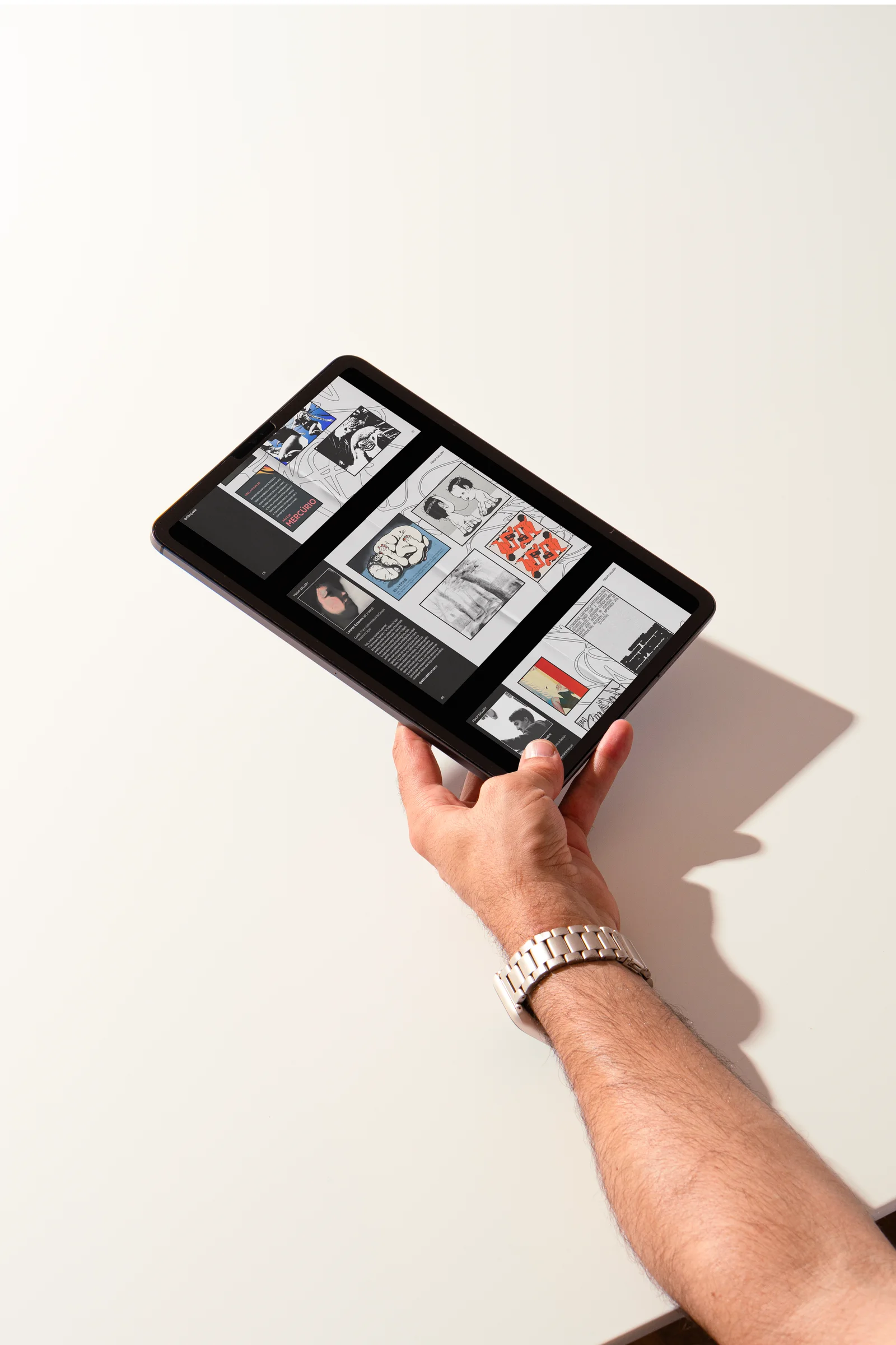 The fanzine spreads shown on a tablet, held in hand